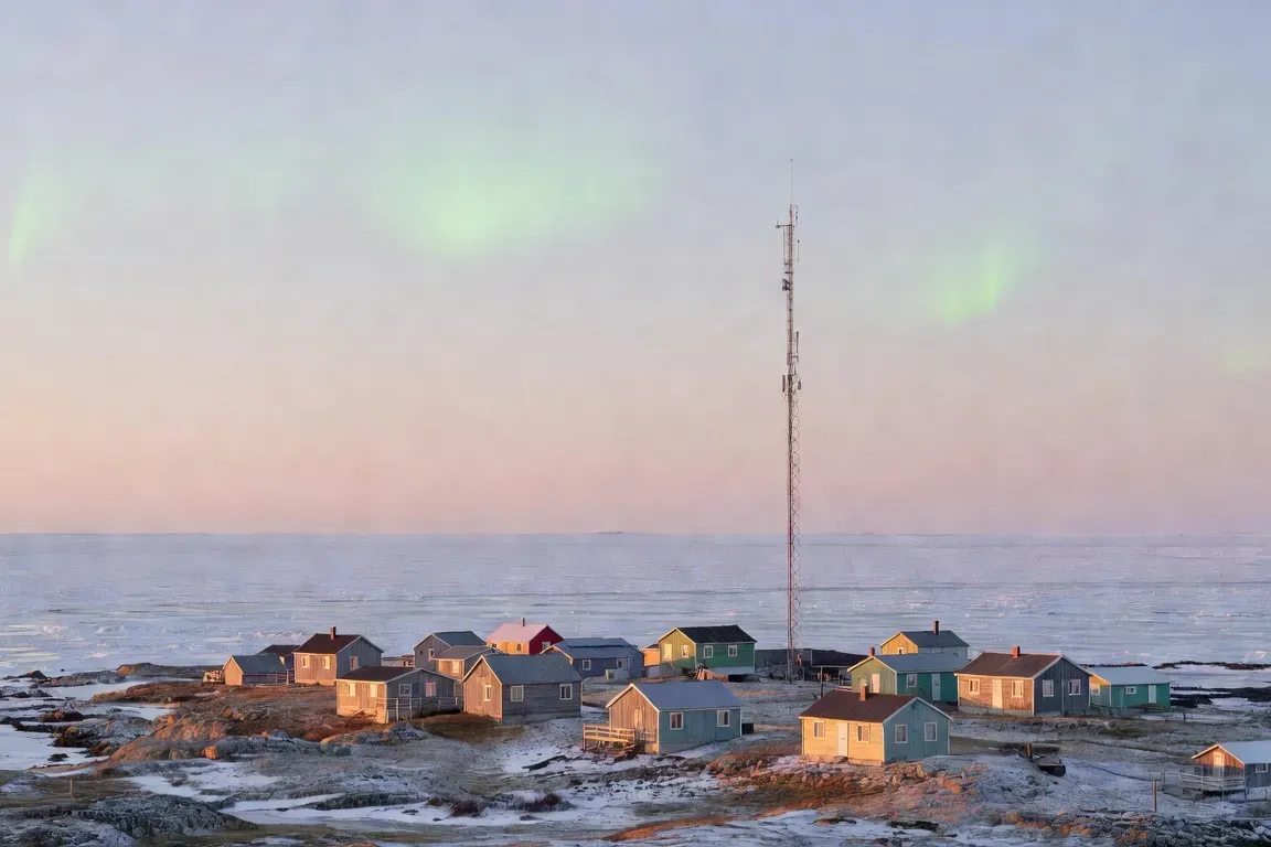 Village côtier du Nunavik au coucher de soleil avec antenne télécom et toundra arctique