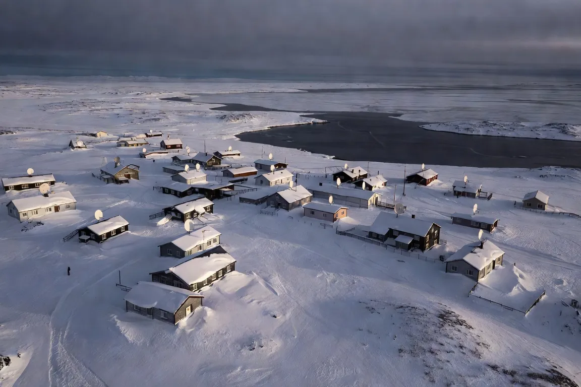 Vue aérienne d'un village côtier du Nunavik en hiver avec des antennes satellite visibles sur les toits